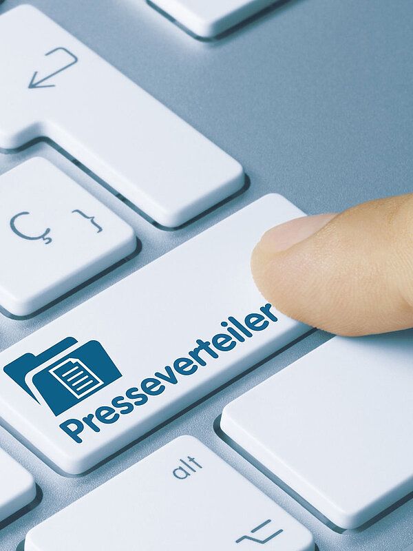 Computertastatur mit Taste "Presseverteiler", Finger klickt 